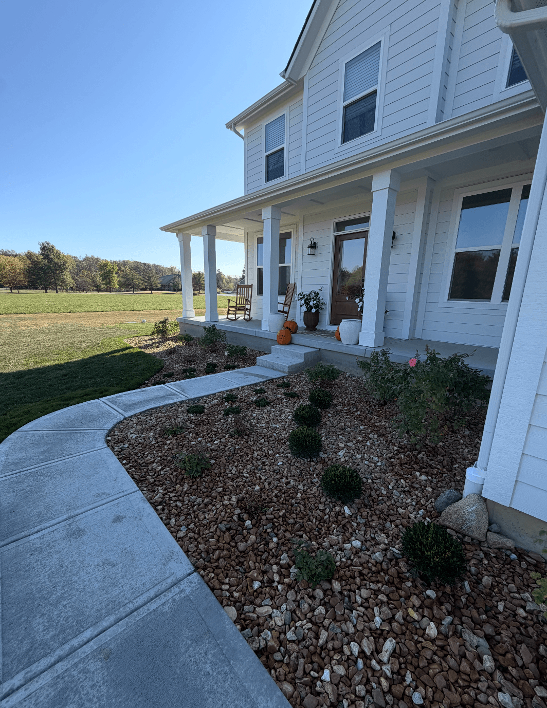 Full Property Landscape Installation With Concrete Walkway and Gravel Driveway image
