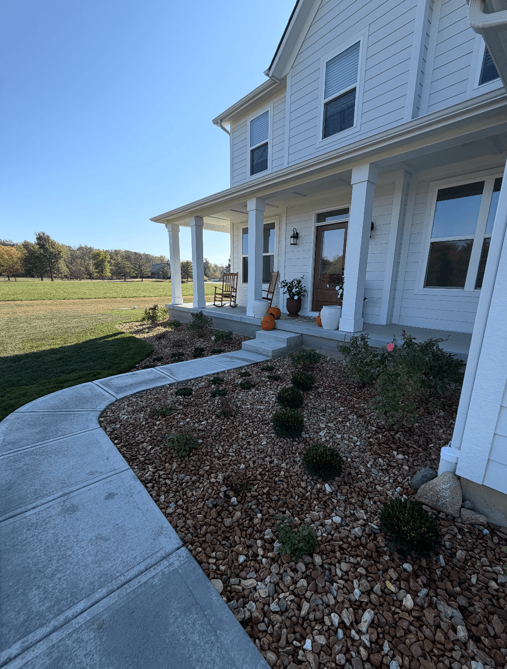 Full Property Landscape Installation With Concrete Walkway and Gravel Driveway image